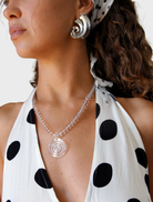 The woman sports a brown top and the Elara Necklace, highlighted by a striking amber stone.