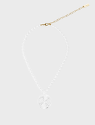 A woman in a brown top wears the Elara Necklace featuring a large amber stone.