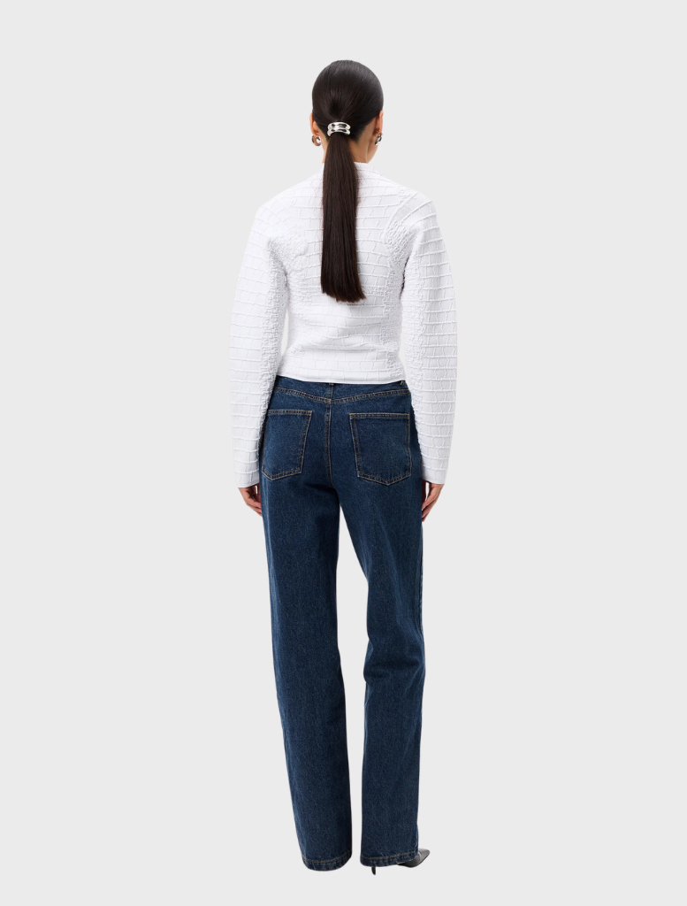 Elegant white Carter Cardigan hanging, showcasing a timeless style and comfortable fit for everyday outfits.