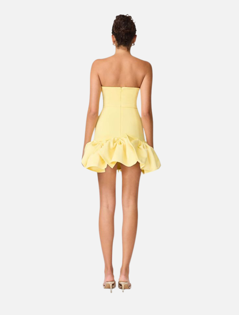 Back view of a woman wearing the Evee Strapless Mini Dress in Lemon, showcasing its vibrant yellow color.