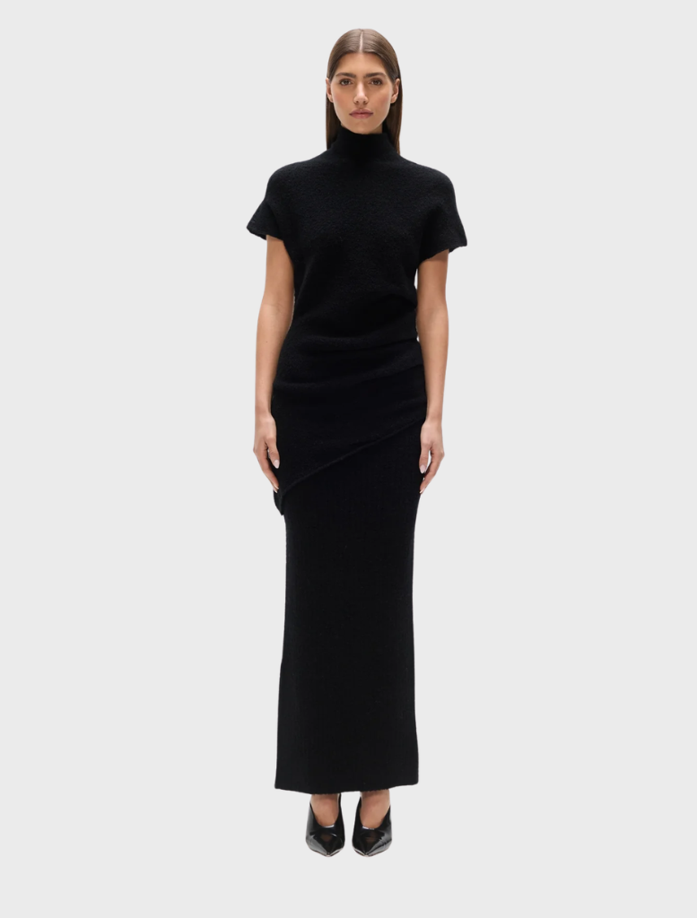 Black Evren knit top displayed on a hanger, showcasing its soft texture and stylish design.