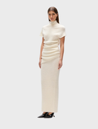 White Evren knit top displayed on a hanger, showcasing its soft texture and casual design.