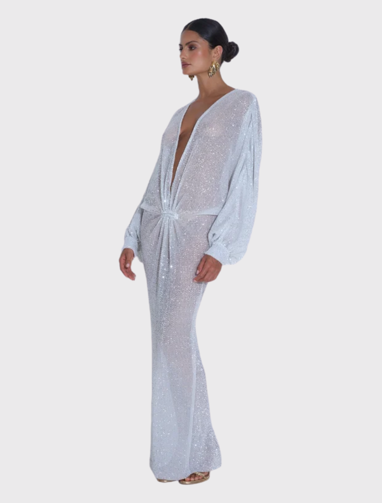 Modern gown in sparkle, featuring a deep neckline and voluminous sleeves, designed for a graceful and elongated look.