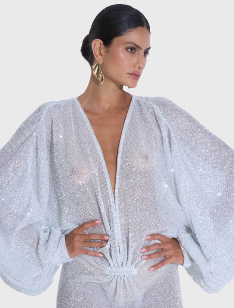 Experimental gown featuring a deep plunging neckline, long sleeves, and a floor-length silhouette in glitter colour.