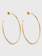 Gold hoop earrings with a hammered finish, designed by Emma Pills, featuring a stud back closure for sensitive ears.
