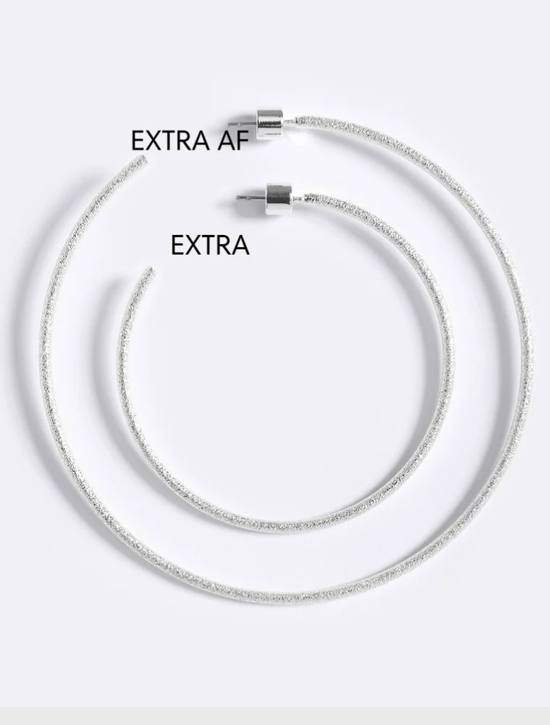 Emma Pills' silver Extra Her Hoops showcase a hammered design, stud closure, and are suitable for sensitive ears.