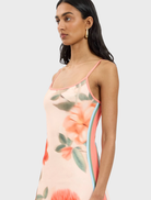 Stylish fitted mini dress in peach adorned with a delicate floral design, perfect for casual or semi-formal occasions.