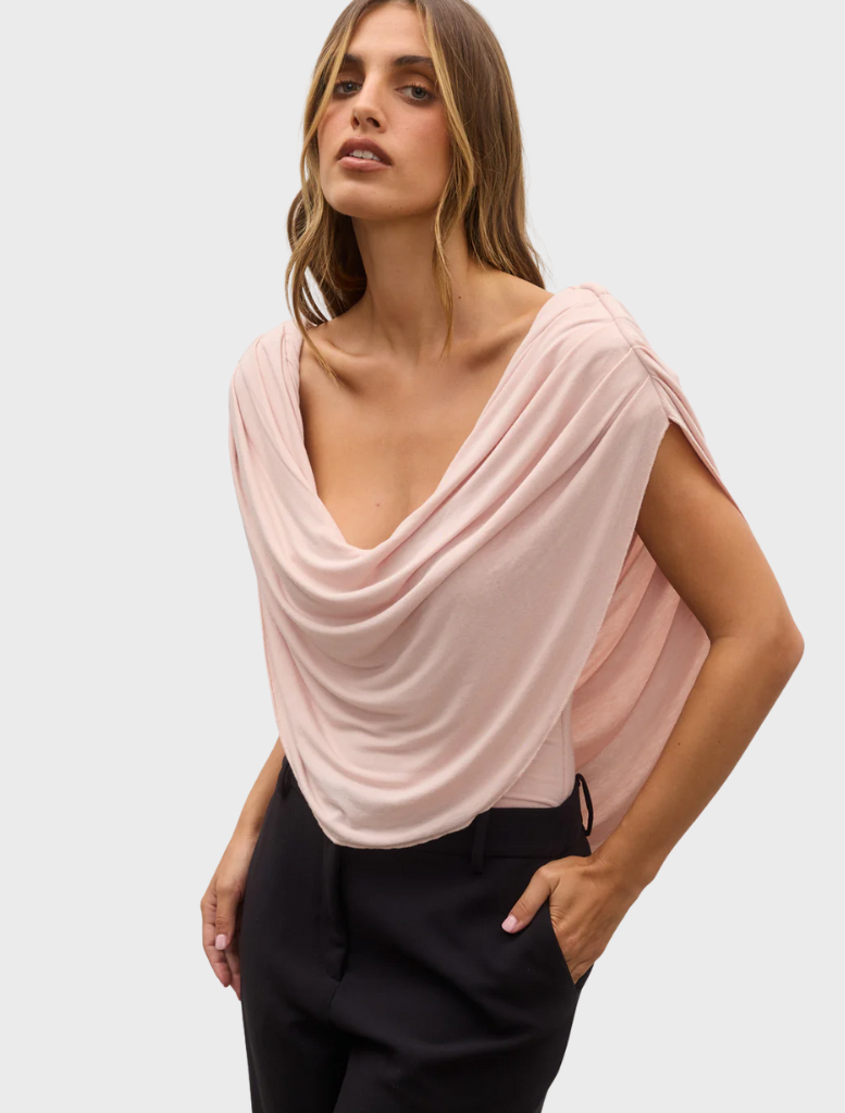 Model wearing a pink Flora Bodysuit and black pants, showcasing a stylish and modern outfit.