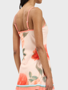 Fitted mini dress in peach with a floral pattern, showcasing a stylish and feminine design.