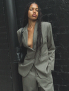 Isla Blazer in forest green, featuring a structured fit and sleek lines, hanging against a neutral background.
