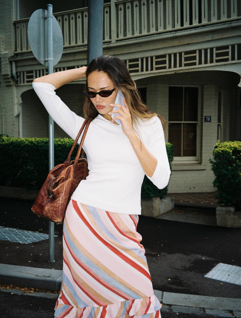 Elegant blush stripe midi skirt with a frill hem, ideal for adding a feminine touch to any outfit.