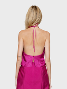 Back view of a woman in a fuchsia high-neck dress, showcasing the elegant design of the Joyas Cowl Top.