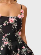 Black Gaia Floral Mini Dress featuring a floral pattern and a fitted silhouette, perfect for casual or semi-formal occasions.