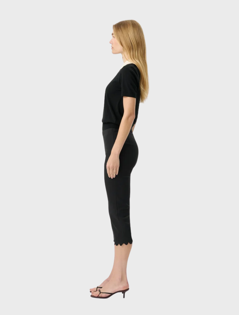 Black fitted knit top with short sleeves and a scalloped collar, offering a modern and vintage-inspired design.