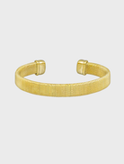 A gold cuff bracelet featuring a sleek, modern design, showcasing a polished finish and elegant curves.