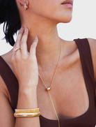 Gold Gisele cuff bracelet displayed on a white background, showcasing its elegant design and shiny finish.