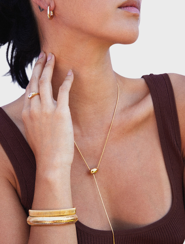 Gold Gisele cuff bracelet displayed on a white background, showcasing its elegant design and shiny finish.