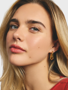 Close-up of shiny gold hoop earrings, showcasing their smooth, circular design.