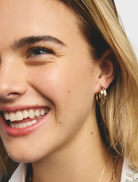 A pair of gold and silver hoop earrings, highlighting their circular shape and reflective surfaces against a neutral backdrop.