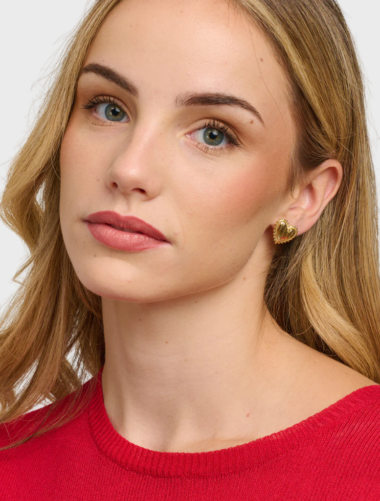  A pair of gold Vanka studs, highlighting their intricate craftsmanship and luxurious appearance against a neutral backdrop.