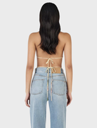 A model displays the Iris Halter Top in Golden Drift, featuring a bright yellow color with a cheerful floral pattern.