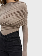 A grey marle bodysuit named Ariya, hanging to highlight its modern cut and comfortable material.