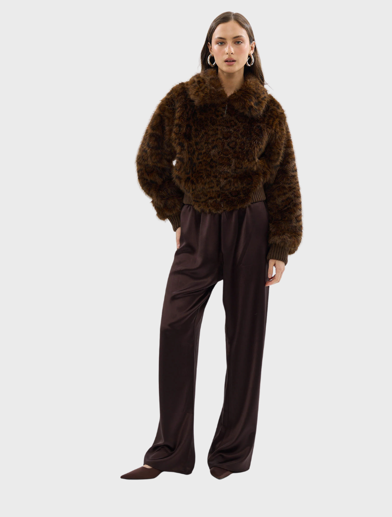 A chocolate leopard faux fur bomber jacket, elegantly draped, highlighting its luxurious fabric and trendy pattern.
