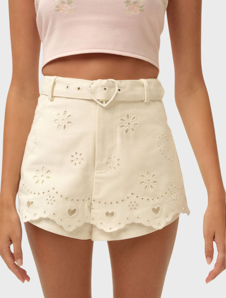 White heart eyelet denim skort featuring a flared design and decorative eyelet details for a stylish summer look.