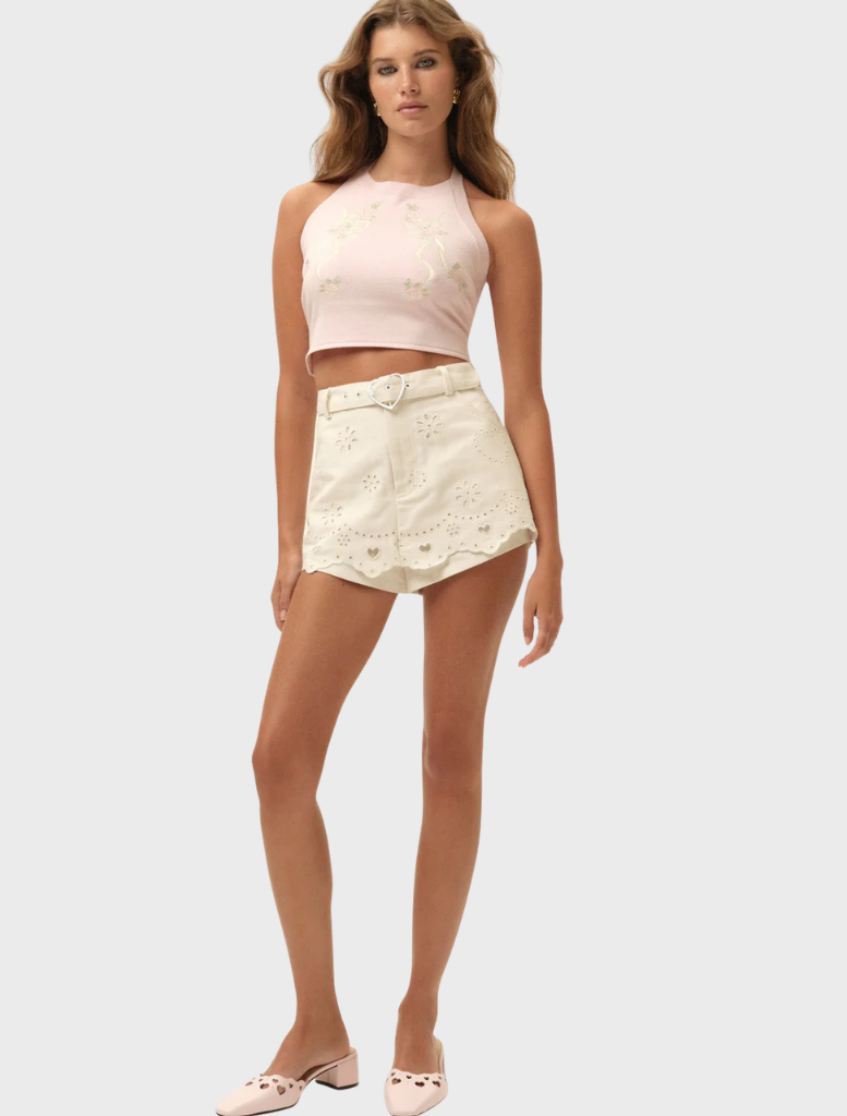 Stylish white denim skort with heart eyelet details, ideal for warm weather and casual wear.