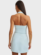 Ice blue halter top crafted from stretch crepe, showcasing a fitted silhouette and triple bind accents on the neckline.
