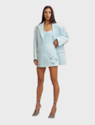 Ice blue mini skirt with an A-line silhouette, adorned with handmade rosettes, made from structured twill and fully lined.