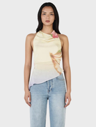 Model wearing a yellow floral print Iris Halter Top in Golden Drift, showcasing a vibrant and stylish summer look.