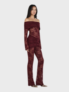 Chic burgundy lace jumpsuit made of lace, offering a fashionable and elegant appearance.