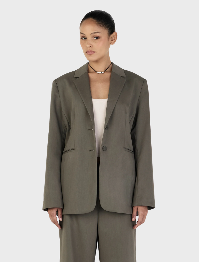 Forest green Isla Blazer displayed on a hanger, showcasing its tailored design and elegant silhouette.