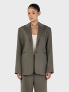 Forest green Isla Blazer displayed on a hanger, showcasing its tailored design and elegant silhouette.