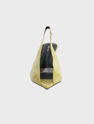 Yellow shoe with a black heel, made of pistachio oily crinkle leather, showcasing a stylish and modern design.