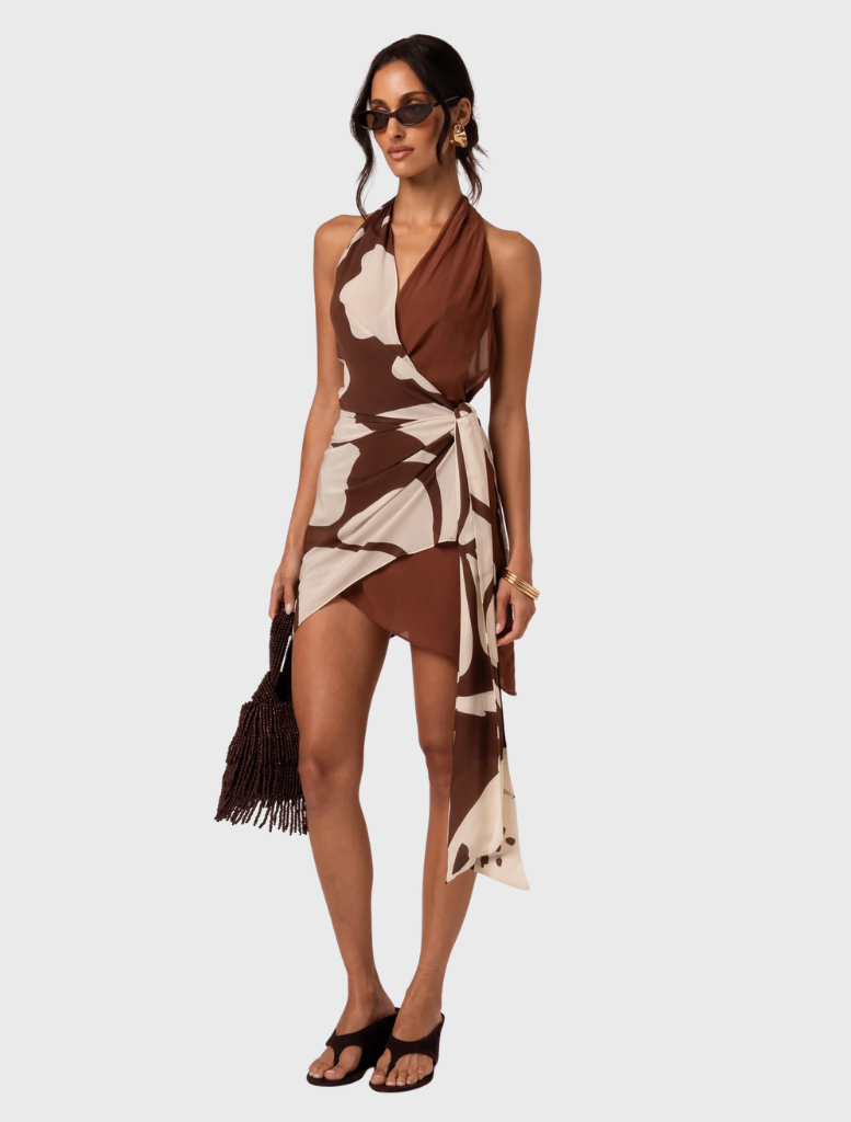 Featuring a halter neck and wrap design, the Ibisco Isola Mini Dress has a floral print and an asymmetric hem for a chic look.