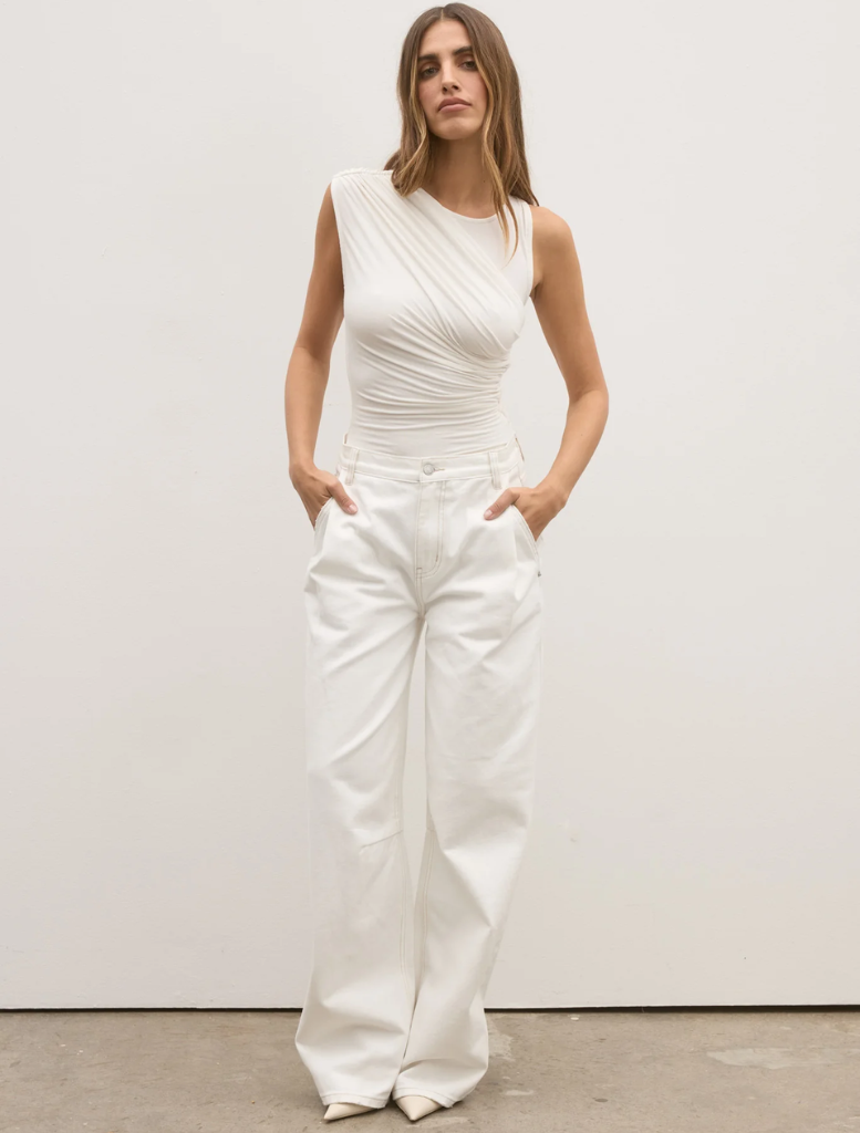 The image features a model dressed in a white Dove top and white pants, emphasizing a clean and elegant look.