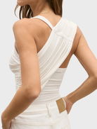 A woman showcases a Dove top in ivory and jeans, embodying a trendy and comfortable outfit.