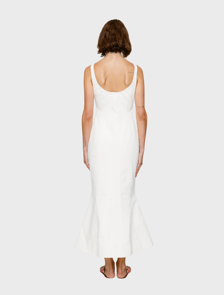Back view of a woman in an ivory Sibel Denim Dress, showcasing the elegant design and flowing fabric.