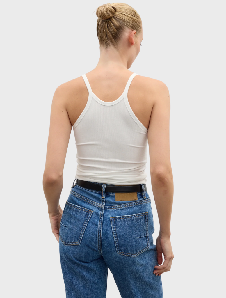 A white Jayla tank top draped on a hanger, emphasizing its clean lines and lightweight fabric perfect for layering.