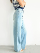  A woman models 94 High & Wide jeans by Jody Blue, wearing wide-legged jeans and a stylish striped top.