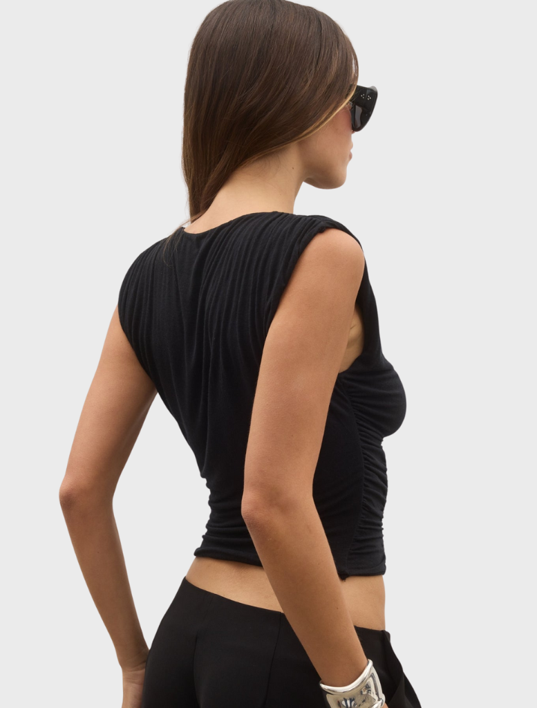 A juniper top in shadow, featuring a contemporary style with deep hues and a refined shape.