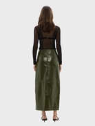 A model wearing a khaki Raye maxi skirt, demonstrating its stylish fit and versatility for different outfits.