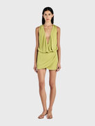 Featuring a relaxed bodice and fitted mini skirt, the Chelley Mini Dress in Kiwi has a deep V neckline and cowl design.