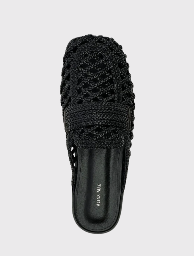 Black woven flat mule named Krissy, with a square toe, wide crossover strap, and open back for convenient slip-on use.