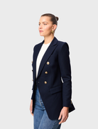 A navy Legacy Blazer shown on a mannequin, highlighting its structured silhouette and elegant style.