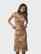 A mesh leopard print midi skirt displayed on a mannequin, showcasing its flowing design and bold pattern.
