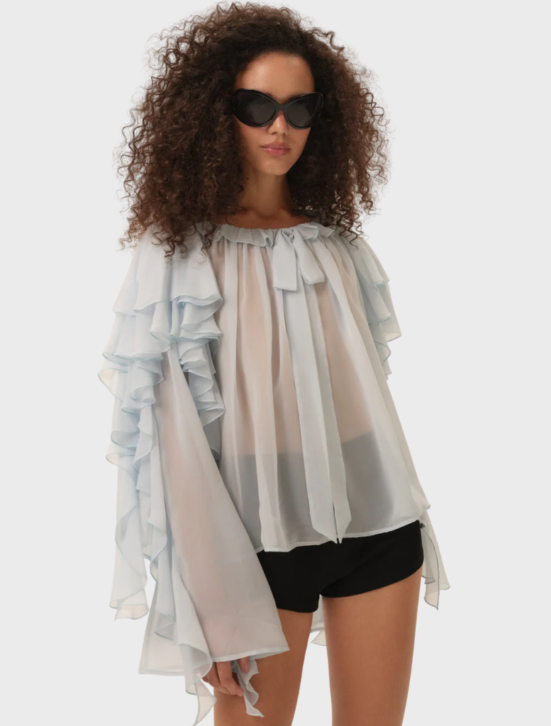 Lila Bow Blouse in blue, featuring a stylish bow detail at the neckline and a soft, flowing fabric.