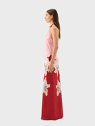 A model displays the Liliana Tallulah Halter Dress, adorned with pink and red flowers.